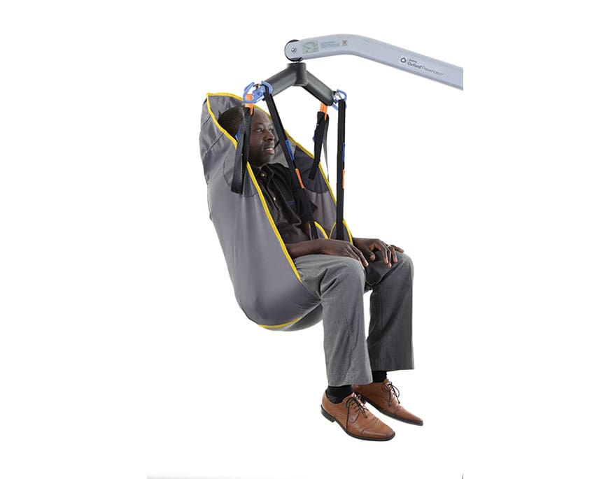 Oxford Full Body (Loops) Sling in use on a hoist, providing full-back and thigh support during passive transfer.