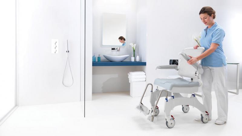 Aquatec Ocean Ergo shower chair positioned in tiled bathroom for mobility and hygiene support