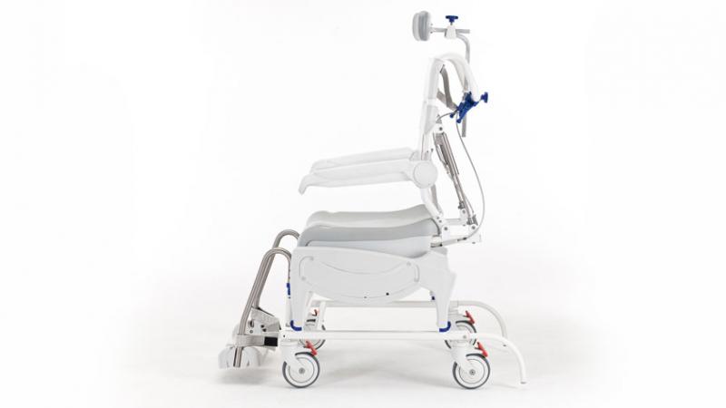 Side profile of the Invacare Aquatec Ocean VIP Ergo Tilt-in-Space Shower Commode showcasing adjustable footrests and armrests.
