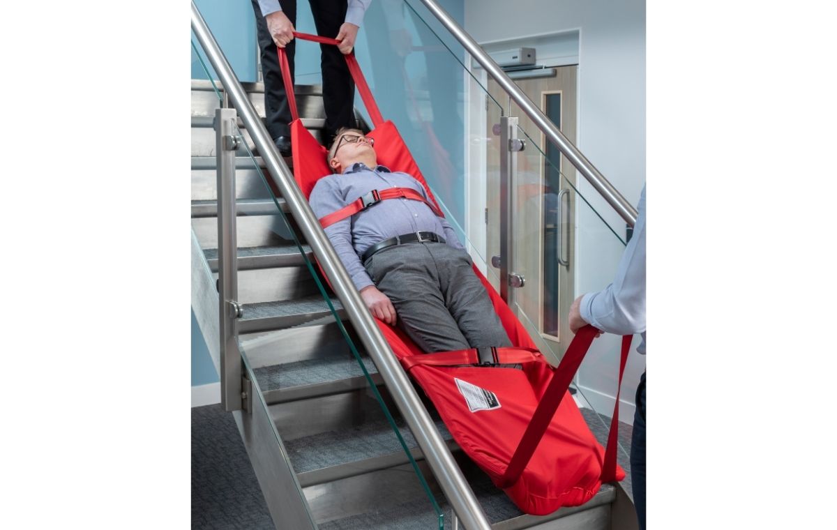 Two‑person operation: carers pulling Alerta Bariatric Evacuation Sledge through doorway
