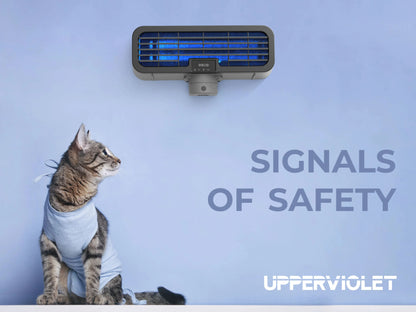 Cat wearing a shirt looking at a Upperviolet ultraviolet air purifier with 'Signals of Safety' text on a blue background.