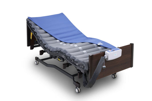 Domus ECO alternating pressure mattress in navy blue placed on a profiling bed, showing air cell structure and slight incline