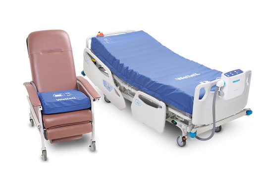 Procare Auto G3 mattress in clinical setting with caregiver adjusting controls, highlighting its integration in patient care