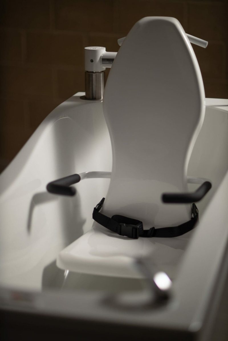 Astor Compact Plus assisted bath with tilt and spa options. Seat in bath.