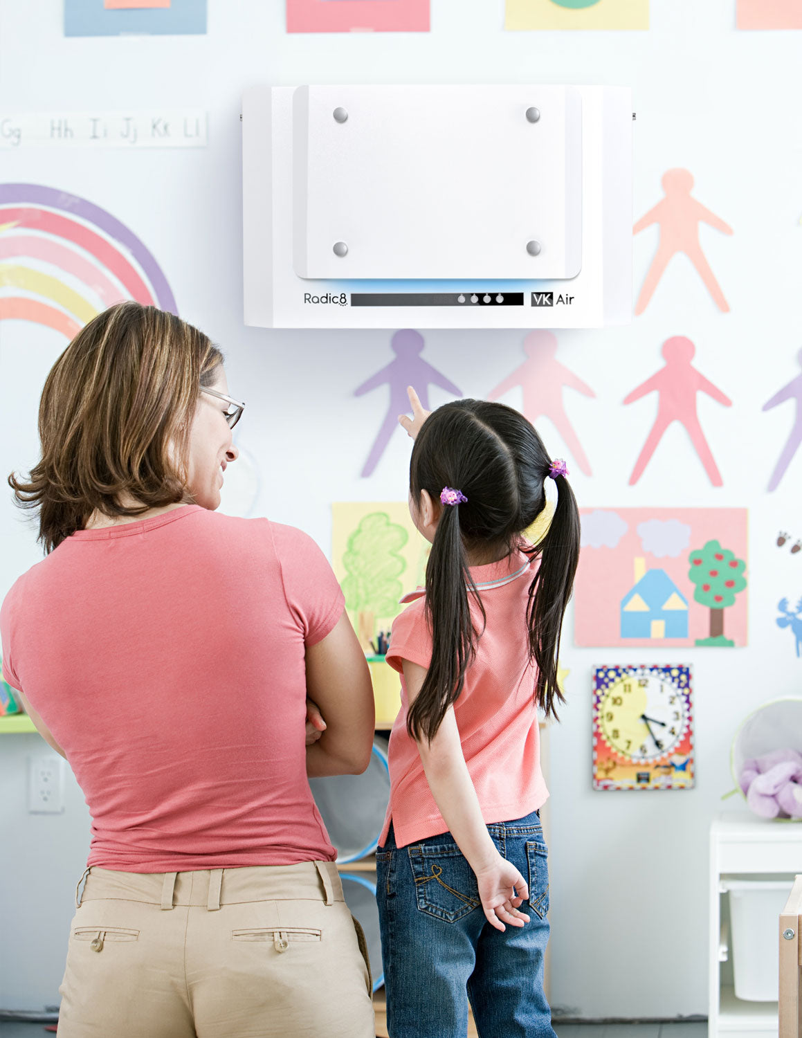 A teacher and their student looking at a Radic 8 air purification unit.