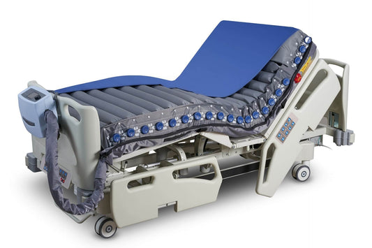 Optima Prone prone-position mattress fitted on a hospital bed, showing the full alternating air cell surface and shoulder-lift section.