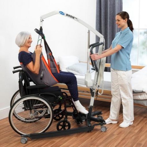 A Birdie Evo Mobile hoist being used in a demonstration. Featuring a service user being lifted safely in a sling.